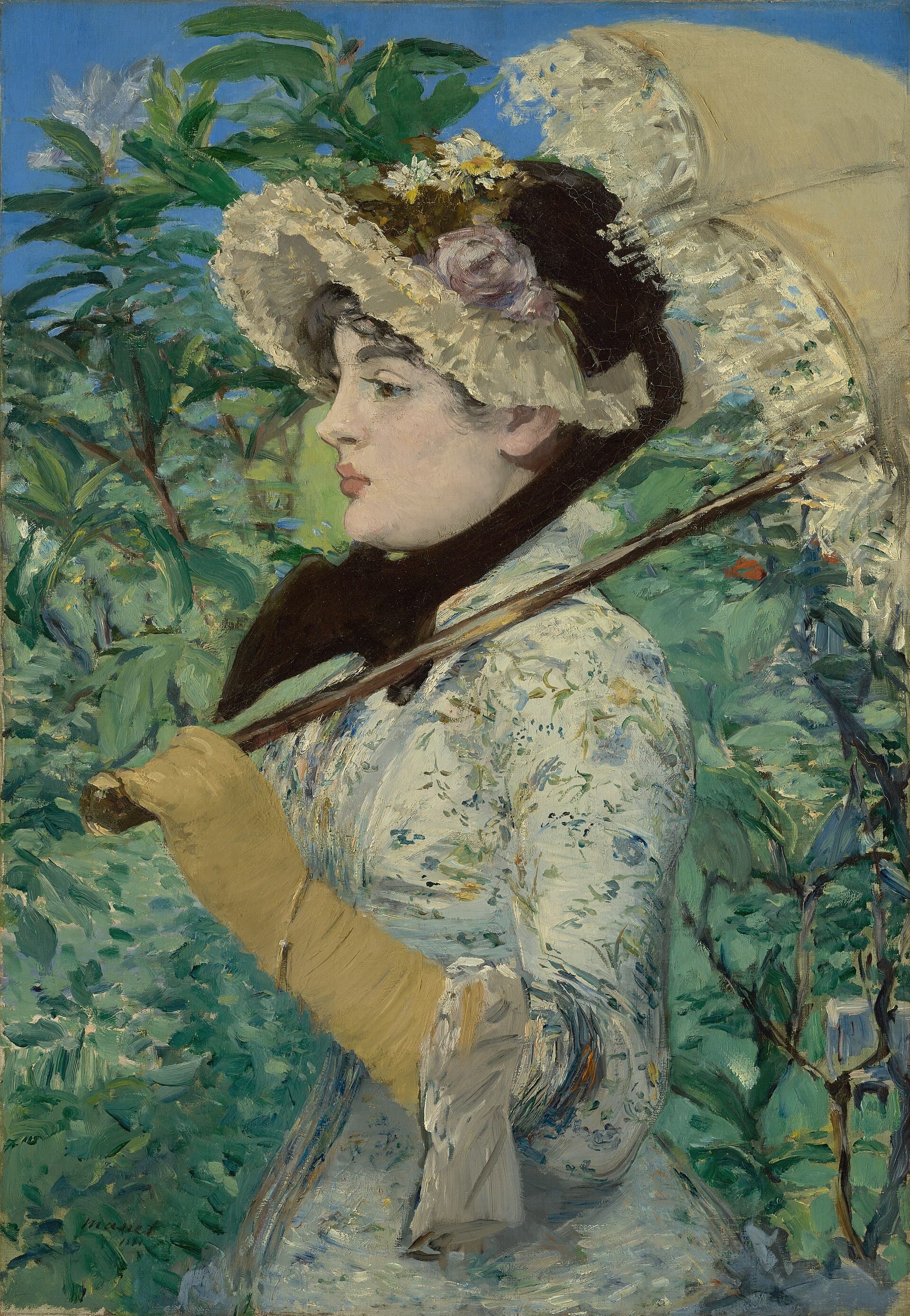 A young woman in a floral-trimmed hat and white dress gazes away, surrounded by lush spring foliage.