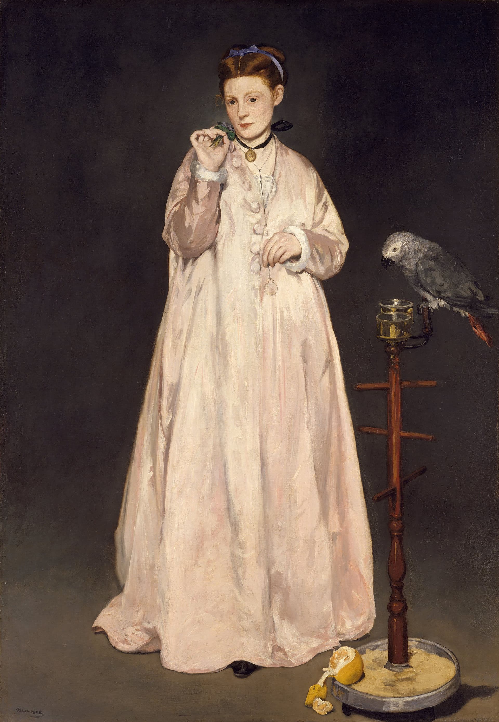 A young woman in a pink negligée holds a violet and extends her arm to a grey parrot on its perch.